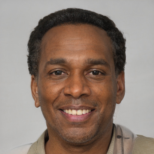 Joyful black adult male with short  black hair and brown eyes