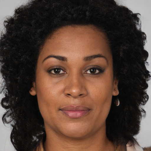Joyful black adult female with long  brown hair and brown eyes