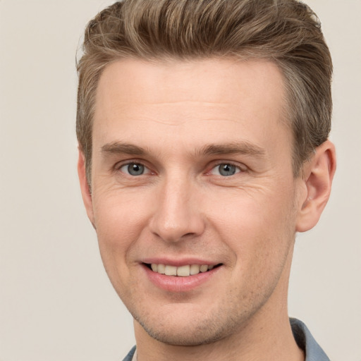 Joyful white young-adult male with short  brown hair and grey eyes