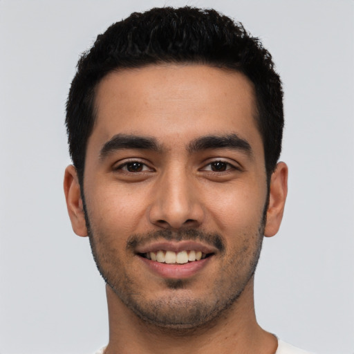 Joyful latino young-adult male with short  black hair and brown eyes