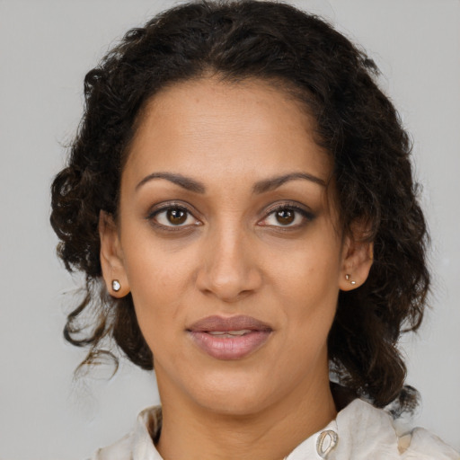 Joyful latino adult female with medium  brown hair and brown eyes