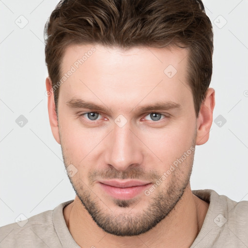 Joyful white young-adult male with short  brown hair and grey eyes