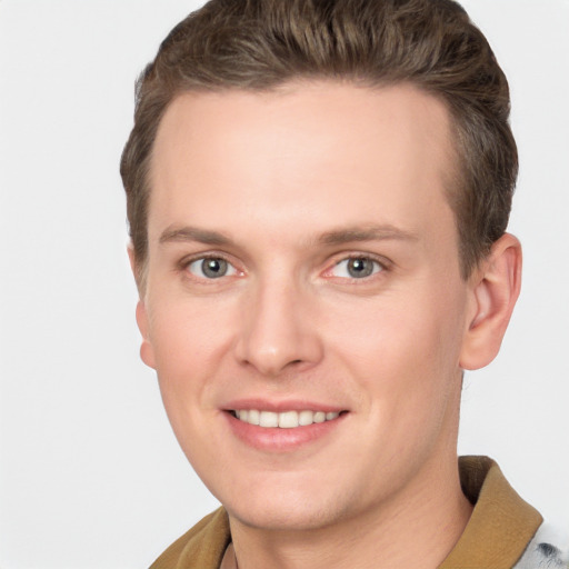 Joyful white young-adult male with short  brown hair and grey eyes