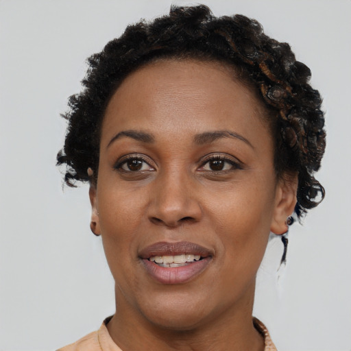 Joyful black young-adult female with short  brown hair and brown eyes