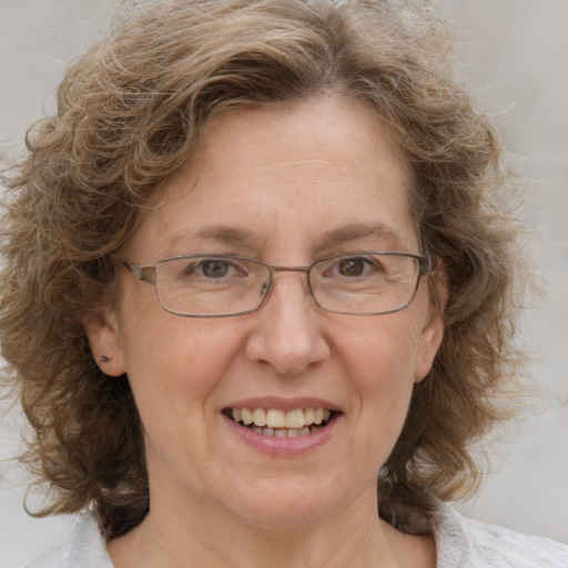 Joyful white middle-aged female with medium  brown hair and blue eyes