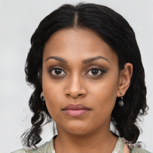 Joyful black young-adult female with long  black hair and brown eyes