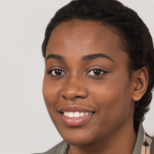 Joyful black young-adult female with short  black hair and brown eyes