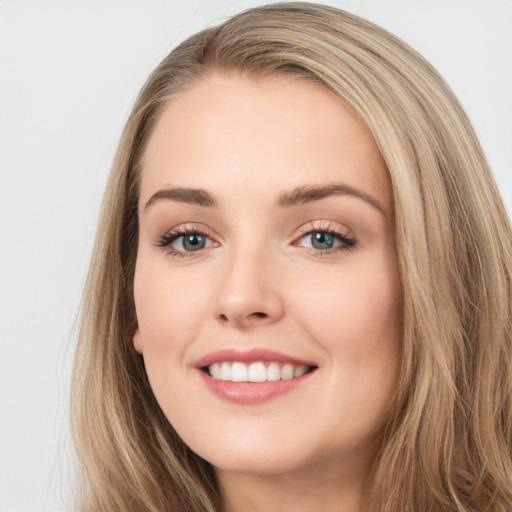 Joyful white young-adult female with long  brown hair and blue eyes