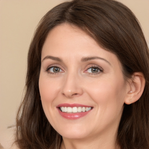 Joyful white young-adult female with long  brown hair and brown eyes