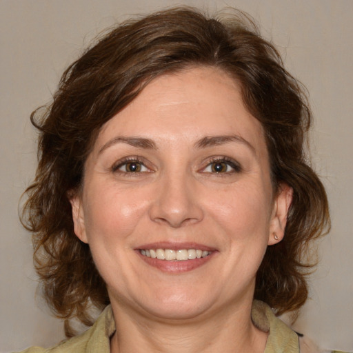 Joyful white adult female with medium  brown hair and brown eyes