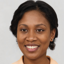 Joyful black adult female with medium  brown hair and brown eyes