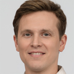 Joyful white young-adult male with short  brown hair and grey eyes