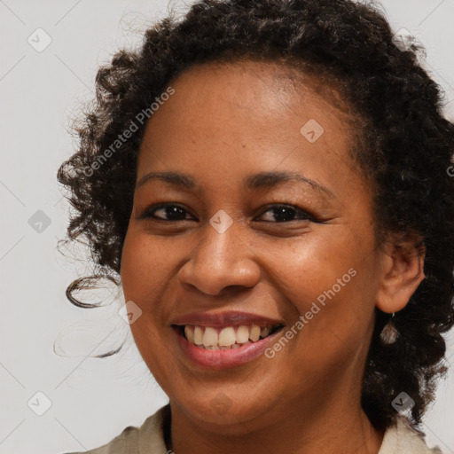 Joyful black young-adult female with long  brown hair and brown eyes