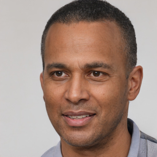 Joyful latino adult male with short  black hair and brown eyes