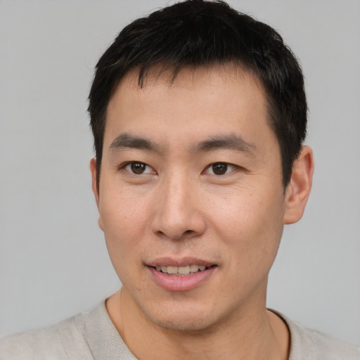 Joyful asian young-adult male with short  brown hair and brown eyes