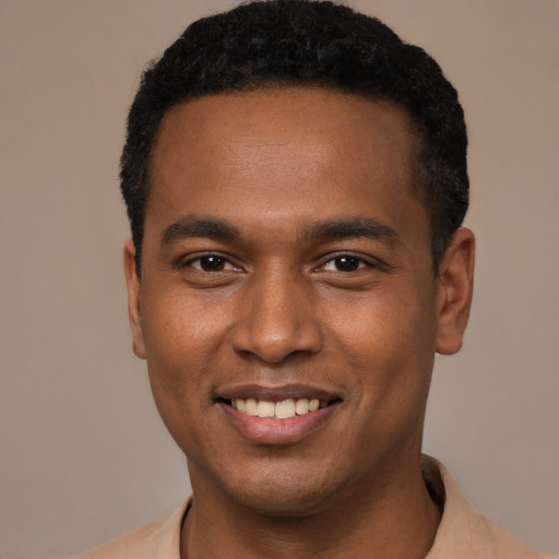 Joyful black young-adult male with short  black hair and brown eyes