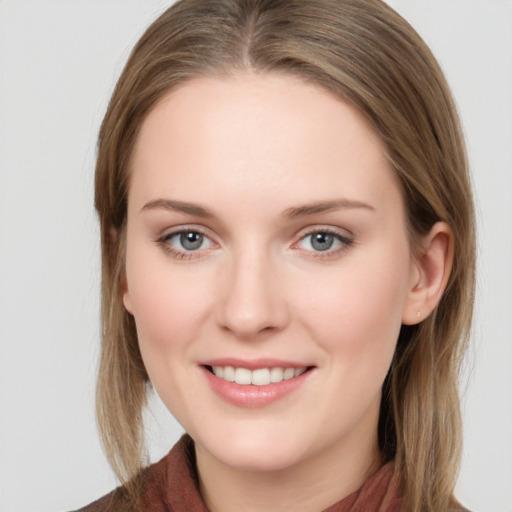 Joyful white young-adult female with long  brown hair and blue eyes