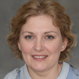 Joyful white adult female with medium  brown hair and blue eyes