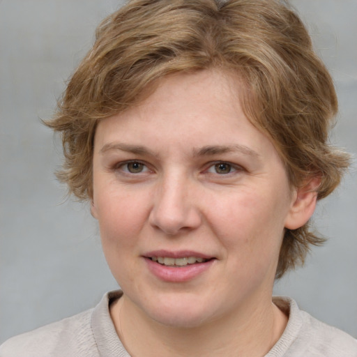 Joyful white young-adult female with medium  brown hair and blue eyes