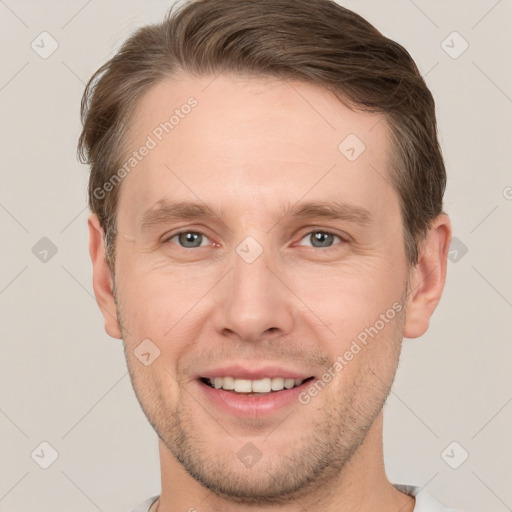 Joyful white young-adult male with short  brown hair and grey eyes