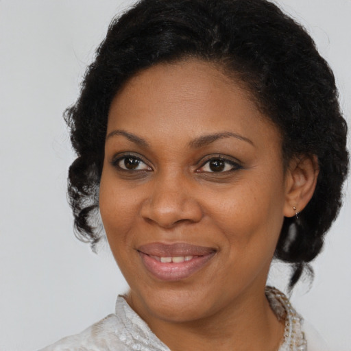 Joyful black adult female with medium  brown hair and brown eyes
