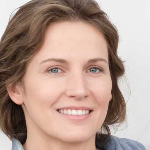 Joyful white young-adult female with medium  brown hair and blue eyes