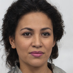 Joyful latino adult female with medium  brown hair and brown eyes