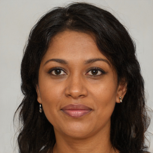 Joyful black adult female with long  brown hair and brown eyes