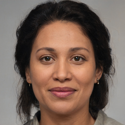 Joyful latino adult female with medium  brown hair and brown eyes