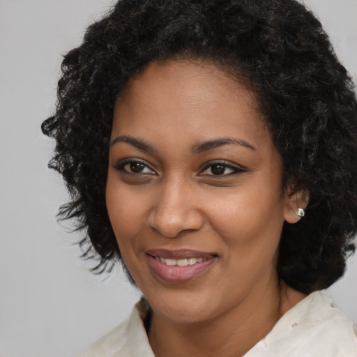Joyful black young-adult female with long  brown hair and brown eyes