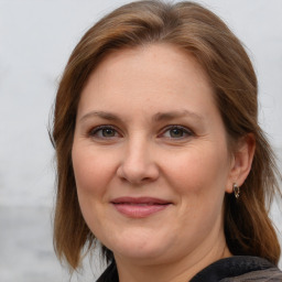 Joyful white adult female with medium  brown hair and grey eyes