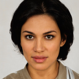 Joyful latino young-adult female with medium  brown hair and brown eyes