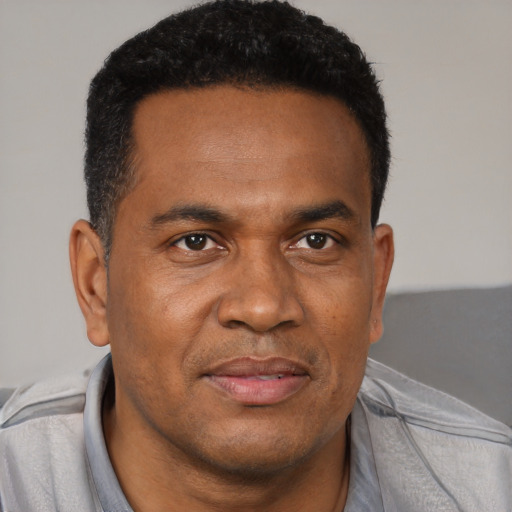 Joyful black adult male with short  black hair and brown eyes