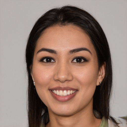 Joyful latino young-adult female with long  brown hair and brown eyes