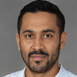 Joyful latino young-adult male with short  black hair and brown eyes