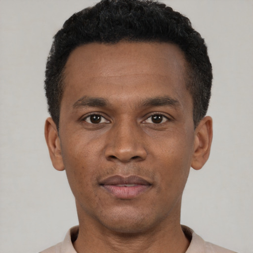 Joyful black young-adult male with short  black hair and brown eyes