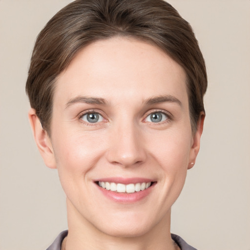 Joyful white young-adult female with short  brown hair and grey eyes