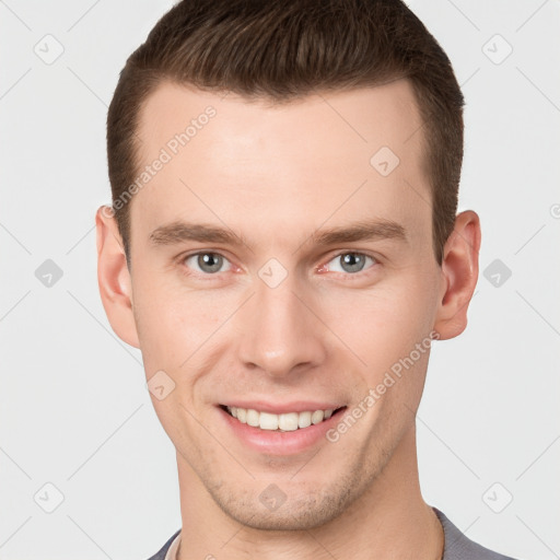 Joyful white young-adult male with short  brown hair and grey eyes