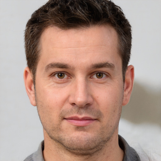 Joyful white adult male with short  brown hair and brown eyes