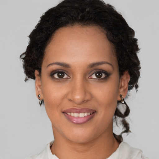 Joyful black young-adult female with medium  brown hair and brown eyes