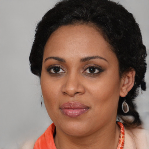 Joyful black young-adult female with medium  brown hair and brown eyes