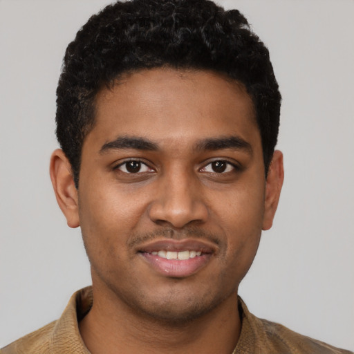 Joyful black young-adult male with short  brown hair and brown eyes