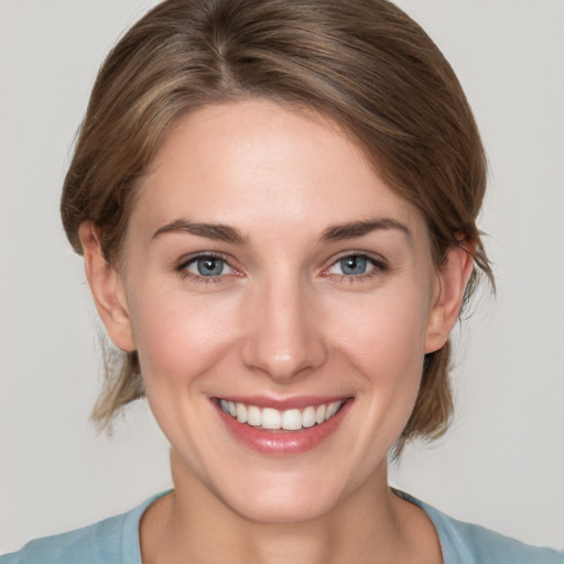 Joyful white young-adult female with medium  brown hair and grey eyes