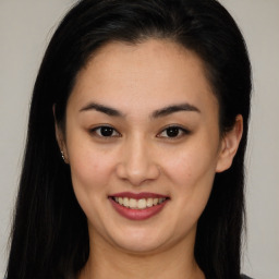 Joyful latino young-adult female with long  brown hair and brown eyes