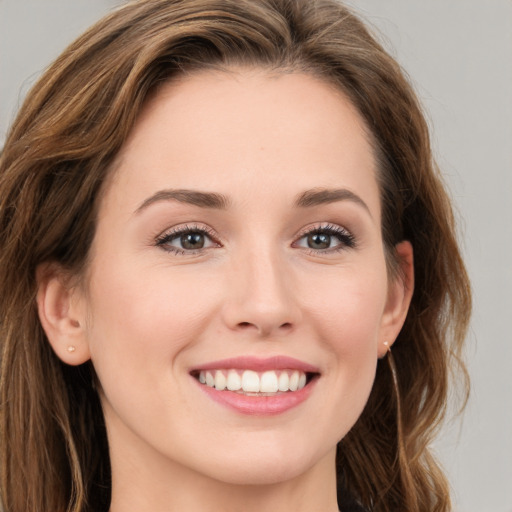 Joyful white young-adult female with long  brown hair and green eyes