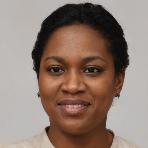 Joyful black young-adult female with short  black hair and brown eyes