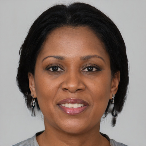 Joyful black adult female with medium  brown hair and brown eyes