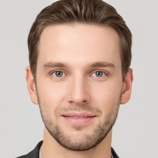 Joyful white young-adult male with short  brown hair and grey eyes