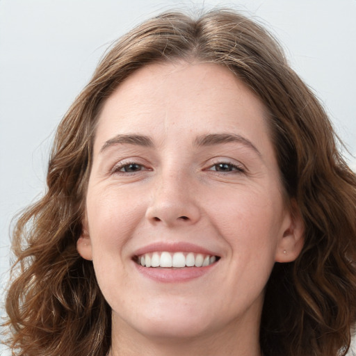 Joyful white young-adult female with long  brown hair and blue eyes