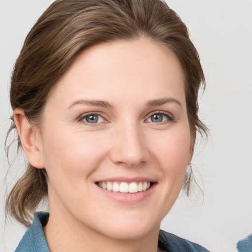 Joyful white young-adult female with medium  brown hair and blue eyes